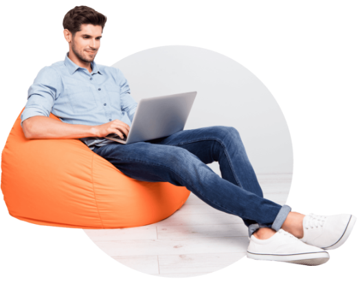 a person sitting on a bean bag with a laptop